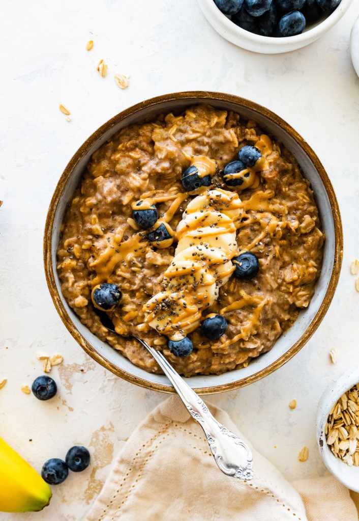 A bowl of oatmeal or whole-grain toast with peanut butter, representing healthier carb choices suitable for nighttime.