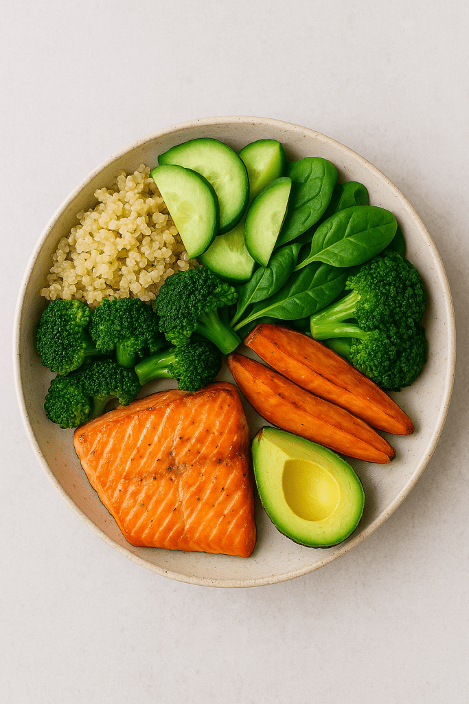 Balanced meal with salmon, quinoa, avocado, and fresh vegetables.