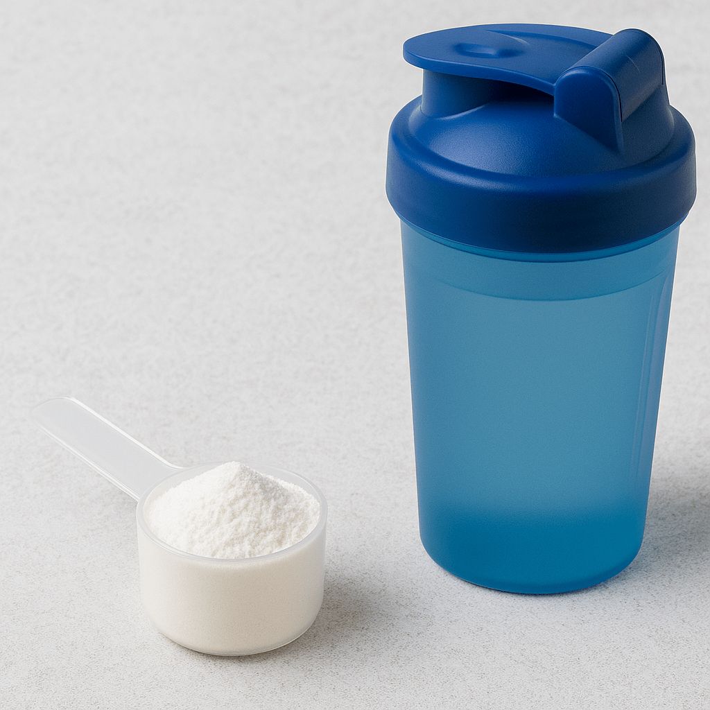 Scoop of creatine powder on a kitchen counter beside a shaker bottle
